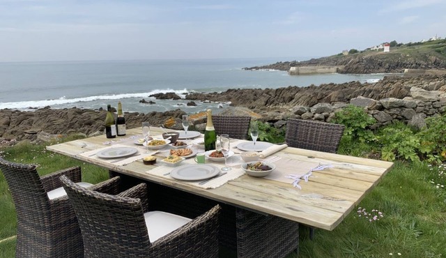 A house with the ocean at the end of the garden