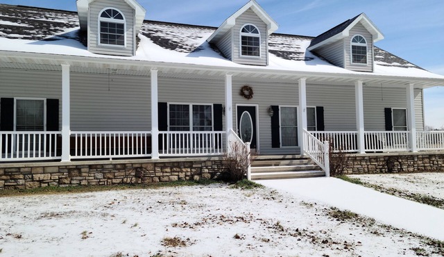 A large country home with scenic views of a working cattle farm & rural locale.