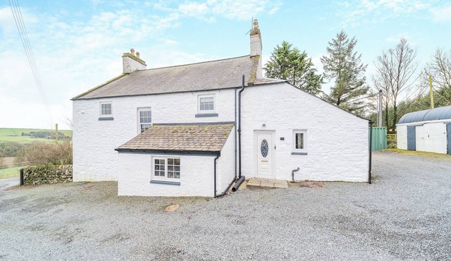 A large, detached farmhouse with open views of the countryside.