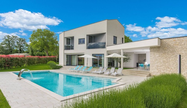 A modern luxury villa with a crystal-clear swimming pool and cultivated garden