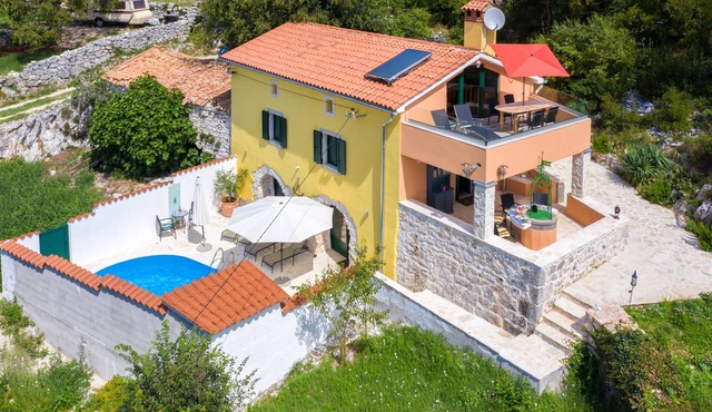 A rustic stone house with pool and sea views.