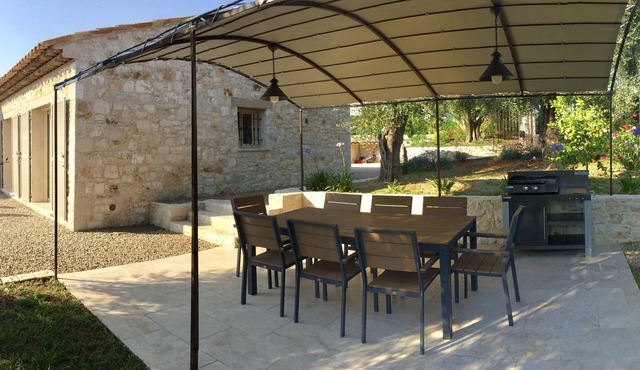 A stone farmhouse in the countryside surrounded by olive trees
