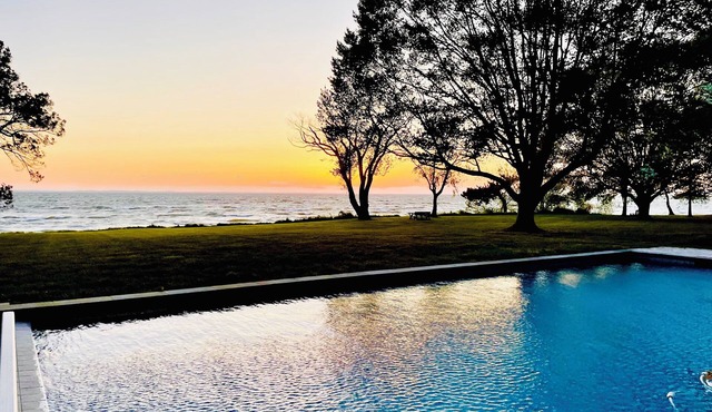 A stunning Chesapeake Bay sunset from a beautiful home with an inground pool!