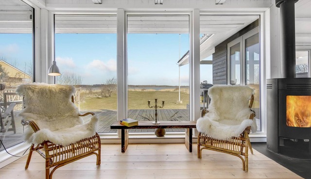 An idyllic setting with cozy furnishings and barrier-free views of the fjord.