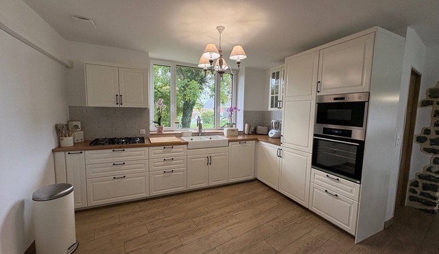 An old-fashioned farmhouse surrounded by animals.