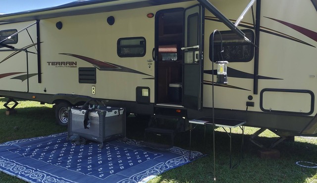 Beautiful travel trailer with private fenced in yard, deck, and fire pit.