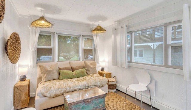 Bohemian-style hotel unit with ample natural light, a cozy seating area,.