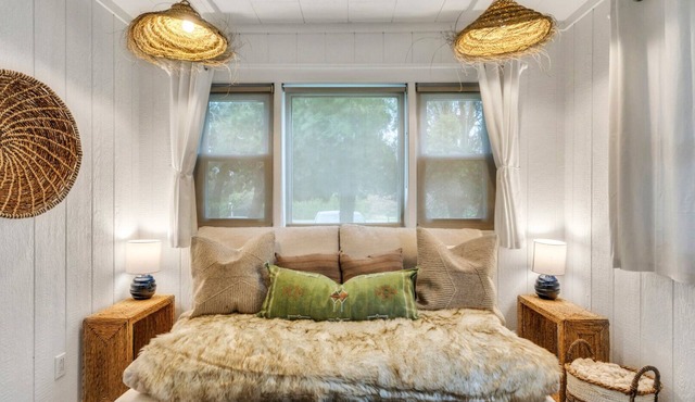 Bohemian-style hotel unit with ample natural light, a cozy seating area,.