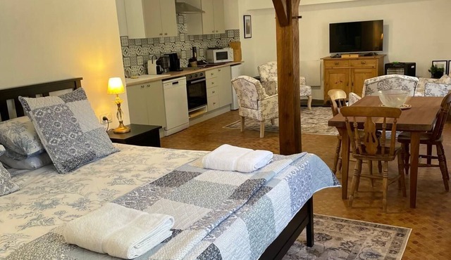 Bright and cozy open-plan studio combining rustic charm with modern comfort.