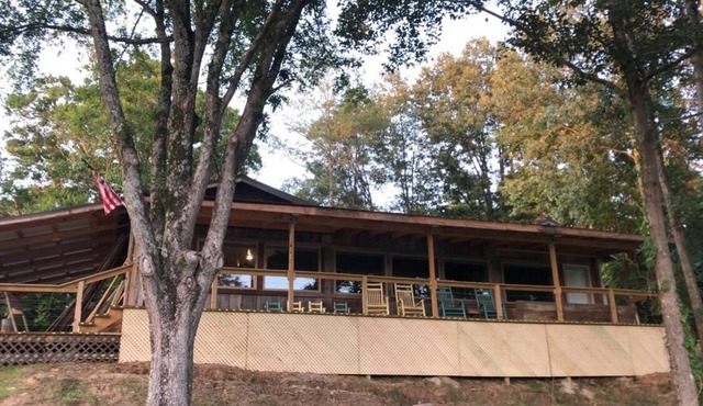 Cabin with 40 ft porch overlooking a pond.
