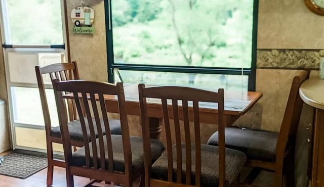Camper in middle of farm setting with creek view