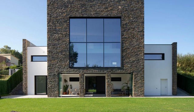Casa moderna con piscina y vistas al bosque.