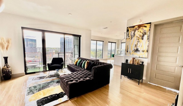 Ceiling to floor windows featuring a private balcony with stunning city views! n