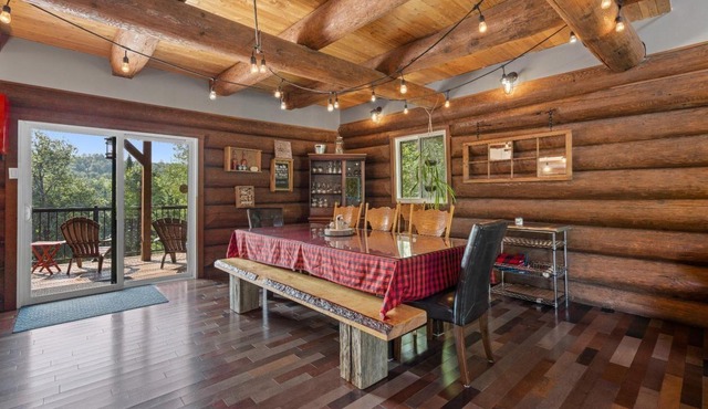 Chalet en bois rond au bord de l'eau avec spa, foyer et table de pool.