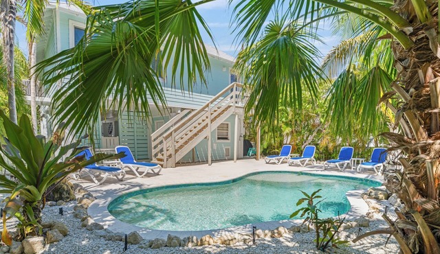Charming cottage with heated pool, tropical landscaping in prime location.