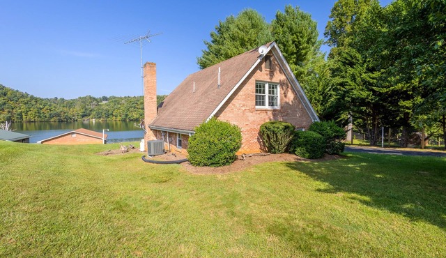 Charming lakefront retreat with cozy interiors, private dock, fire pit, and breathtaking water view