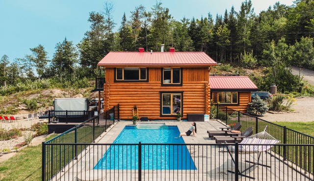 Charming log cabin nestled in the woods, with a spa and in-ground pool.