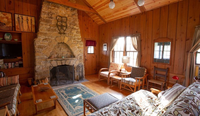 Classic cabin/cottage with big screen porch, stone fireplace, knotty pine walls.