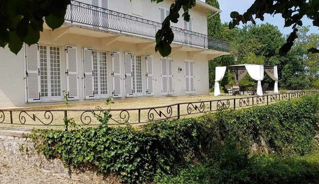 Colonial house surrounded by cliffs and trees