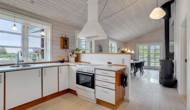 Comfortably furnished cottage with kitchen-living room and a fireplace in the living area.