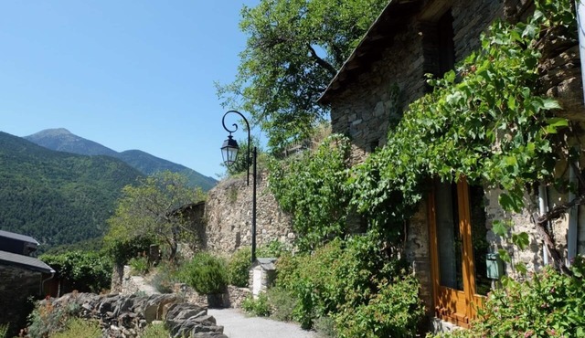 Cottage built into rock face, with spectacular mountain views of the Pyrenees