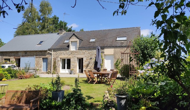 Country house on the edge of a forest with landscaped garden.