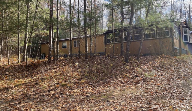 Cozi retreat set in the woods within walking distance of Waubee Lake.