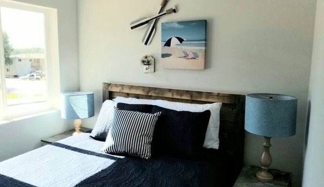 Cozy 2-bedroom suite with full kitchen, living room (couch, 2 chairs), dining table (2 stools), smart TV with cable. Perfect for short or long stays.