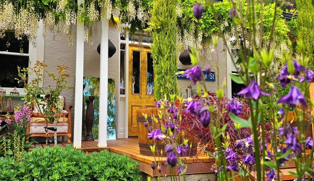 Cozy, beautifully decorated cottage sitting in a stunning seasonal garden