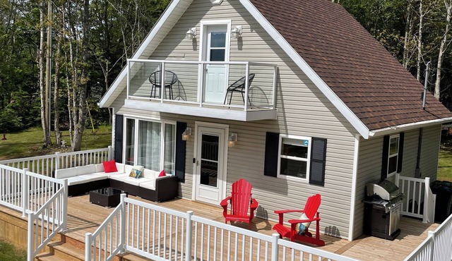 Cozy cabin style cottage tucked into the woods with a view of the water.