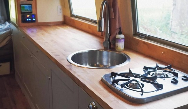 Cozy camper by the creek, surrounded by serenity and nature.