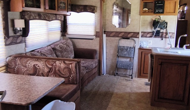 Cozy RV has 2 bedrooms, an outdoor kitchen with a grill & fridge