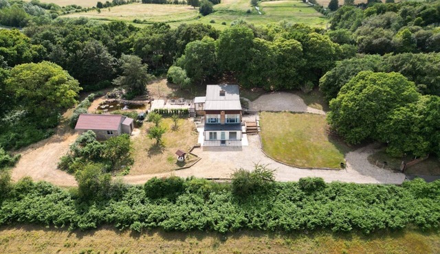 Detached property in woodland surrounding.