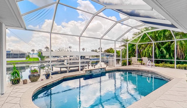 Dog-friendly waterfront home with heated pool, lanai, central AC, & W/D