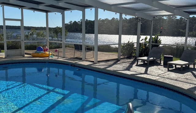 Enjoy this waterfront home with a pool, dock, and Blue Angels! Bring your boat!