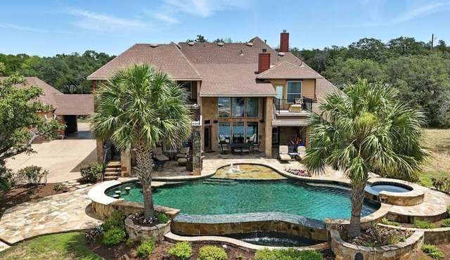 Experience luxury on Lake Travis! Enjoy stunning lake views, a private pool, spa, fire pit, and plenty of space for the whole crew. This gated retreat sleeps 17+ and features a chef’s kitchen, bar, media room, game room, dedicated office, playscape,