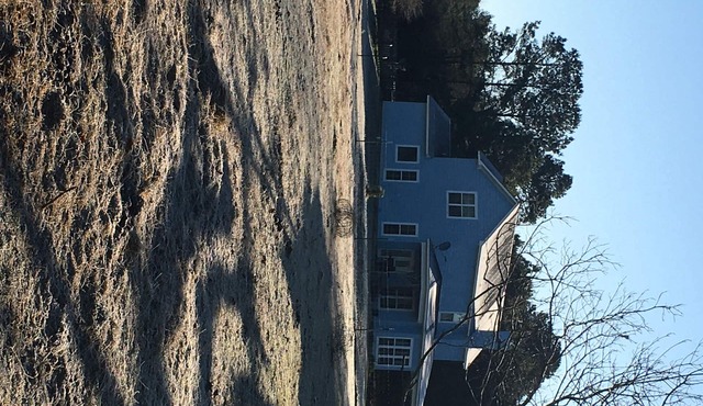 Farm home with horses and cattle on site.