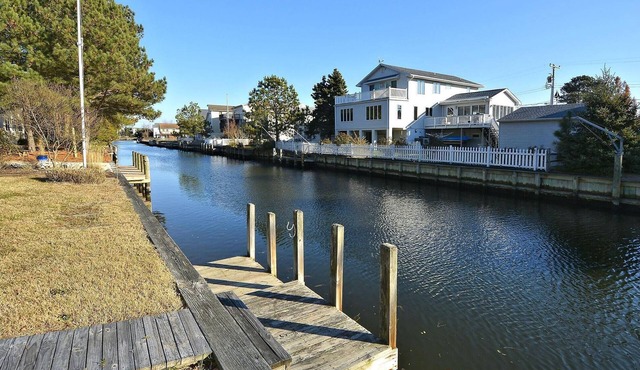 FREE DAILY ACTIVITIES! Lovely 4 bedroom + Den, (Two Master Bedrooms) 3.5 bath home, located on the canal, with boat dock, 2 car garage,just a short walk to the lifequarded beach.