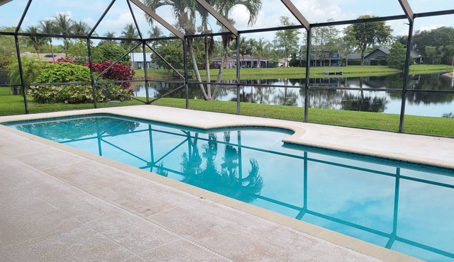 Golf cart distance to WEF! Charming 3 bedroom waterfront home with heated pool.