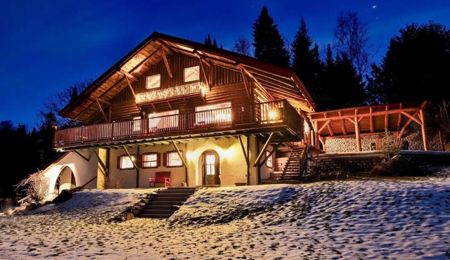 Grand chalet en bois rond relaxant avec un spa.