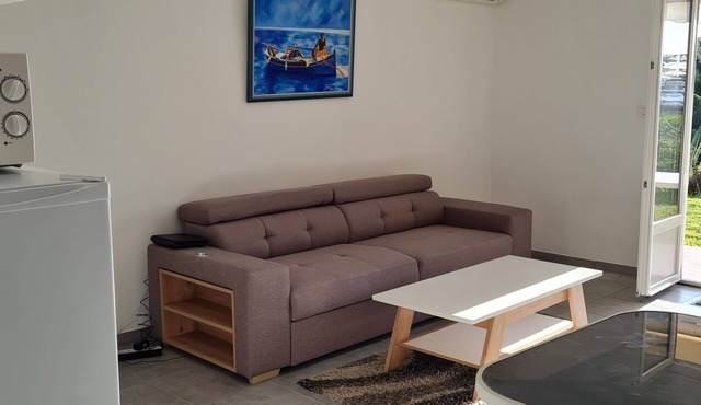 Ground-floor apartment with garden and barbecue near beach and shops.