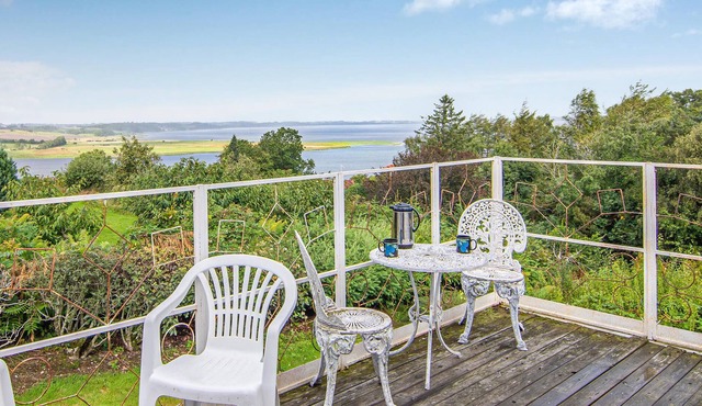 High up, with a fantastic view of the fjord, is this beautiful cottage that provides the setting for