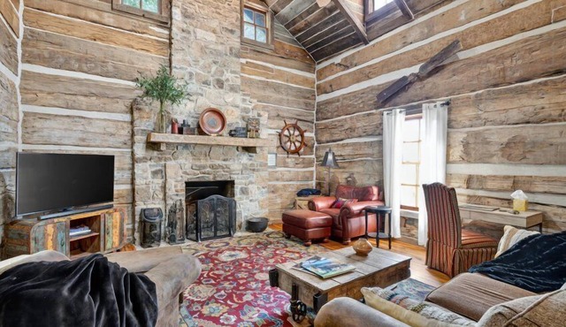 Historic lake-access log cabin on Lake Guntersville, restored from two pre-Civil War cabins. Sleeps 20 with 4BR/5BA, loft bunks, designer finishes, modern comforts, and steps to swimming, fishing & boating.