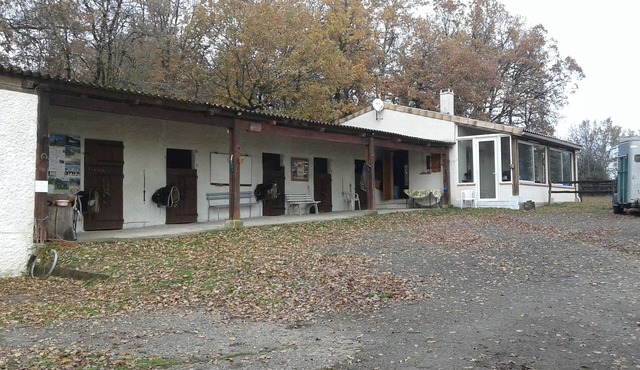 House in a rural setting with horses nearby