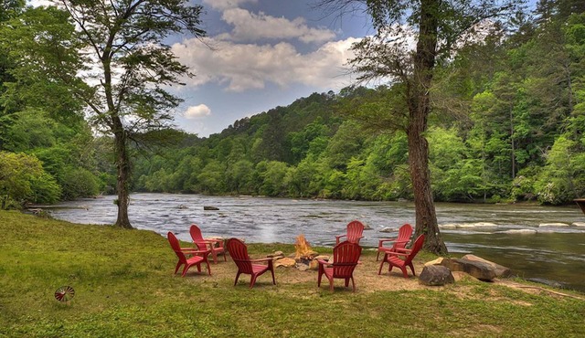 Hunter's Lodge, a pet-friendly riverfront cabin, complete with a pool table, lit basketball court, fire pit, dock, and WiFi