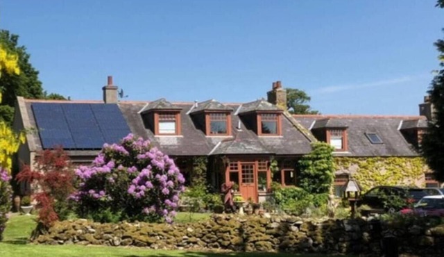 Idyllic countryside haven with lush landscape, manicured garden, pond and stream