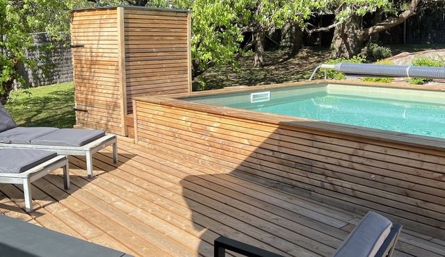 In a green setting, my wooden house with its private swimming pool