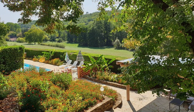 Karakteristiek huis met zwembad en privétuin in een groene omgeving.