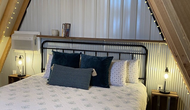 King bed in Tulip Glamping Aframe at Noble Pine Campground