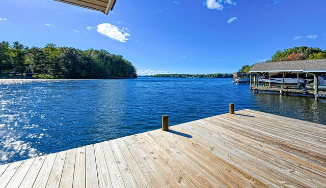 Lakefront home with spacious deck, dock, game room, hot tub, & sunset views